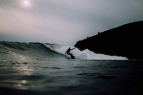 sea man surfing during daytime water